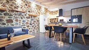 Eine gemütliche Küche mit Steinwand, Holzbalkendecke und modernen Geräten.