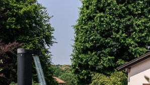 A swimming pool with a waterfall feature, surrounded by lush greenery and two lounge chairs. - Beautiful villa with pool surrounded by nature near Golf and Tennis courts (Beregazzo con Figliaro (Co))