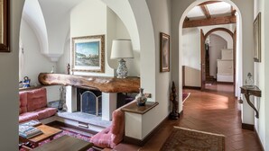 A spacious living room with a fireplace, a pink sofa, and a wooden coffee table. - Beautiful villa with pool surrounded by nature near Golf and Tennis courts (Beregazzo con Figliaro (Co))