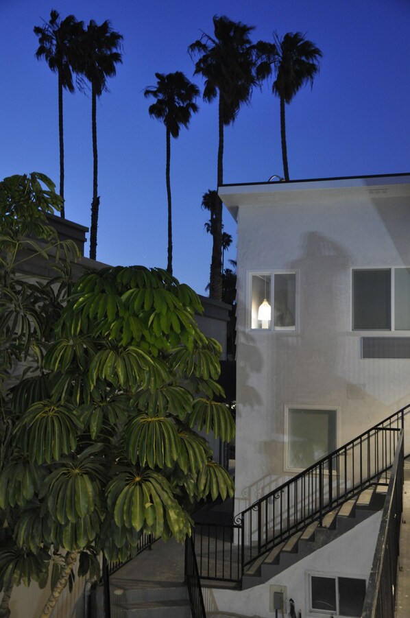 A modern building with a staircase and a view of palm trees. - The Belmont Shore Inn (Long Beach)