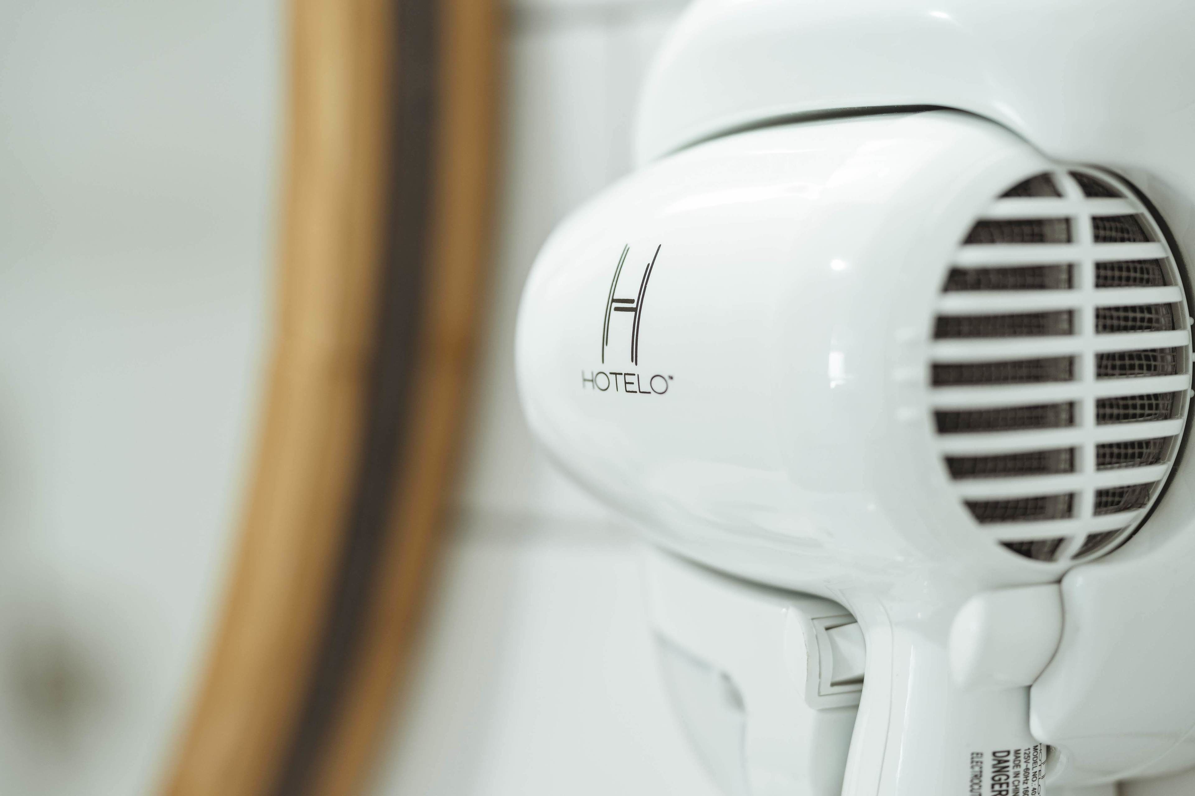 A white hair dryer with the brand name "HOTELO" visible on its front.