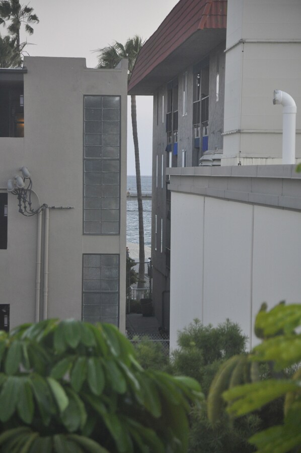 A building with large windows, a red roof, and a view of the sea. - The Belmont Shore Inn (Long Beach)