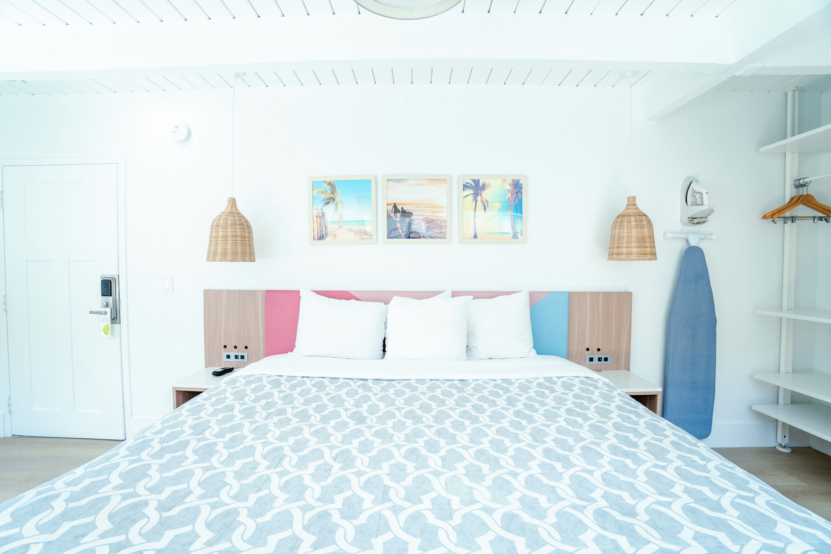 A hotel room with a large bed, a wardrobe, and a shelf with a towel.