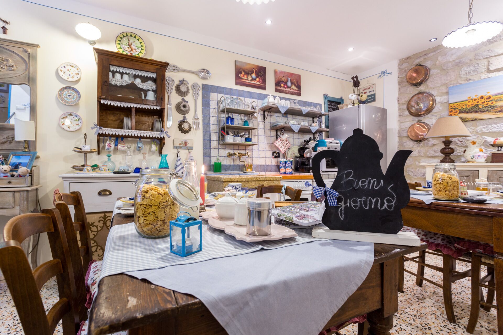 Una cocina acogedora con una mesa de comedor para dos, rodeada de utensilios de cocina y objetos decorativos.