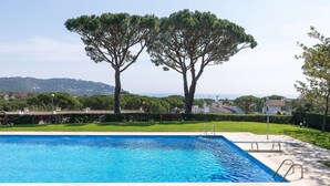 A swimming pool with a clear view of the surrounding landscape, including trees and distant hills.