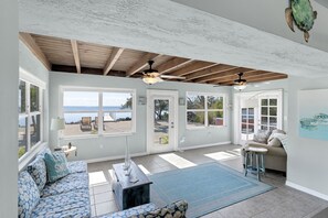 Relax in a spacious room with a seating area, large windows, and a ceiling fan.