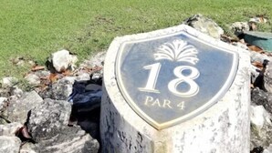 Un parcours de golf avec un panneau indiquant le trou numéro 18 et le par 4.