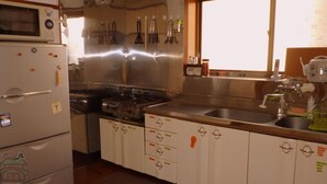 Une cuisine compacte équipée d’un four à micro-ondes, d’une cuisinière, d’un évier et de placards.