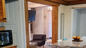 A wooden interior with a dining area, a television, and a kitchen counter.
