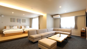 A modern hotel room with a large bed, a sofa, and a coffee table. - Hotel Cocon (Fukuoka)