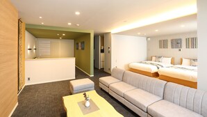 A hotel room with a sofa, two beds, a small table with a vase, and a hallway leading to a bathroom. - Hotel Cocon (Fukuoka)