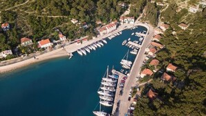 Vista aérea de um porto com barcos atracados, rodeado por edifícios residenciais e vegetação.