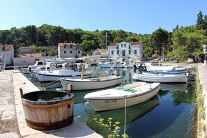 A marina with boats docked, a wooden barrel, and buildings in the background. - Luxury villa with all comforts, swimming pool, 150m from the sea, breathtaking view + mooring (rogac)