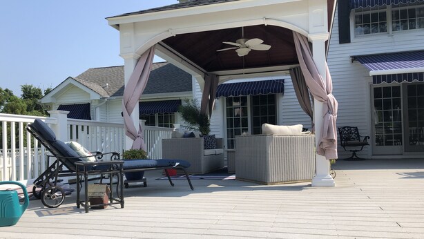 A covered outdoor patio with a ceiling fan, lounge chairs, and a wicker sofa. - Cape May Beautiful Condo(5minutes to the Beach) (Cape May)