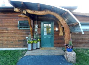 Rustic cabin with a distinctive curved entrance and a charming welcome mat.