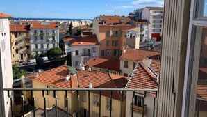 Vista de uma paisagem costeira urbana, com edifícios que exibem telhados vermelhos e varandas.