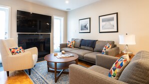 A living room with a sofa, armchair, coffee table, and a fireplace. - Location! 1 Block from Bayshore / SOHO / Hyde Park (Tampa)