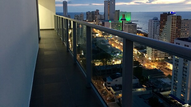 Varanda com vista para a cidade ao entardecer.