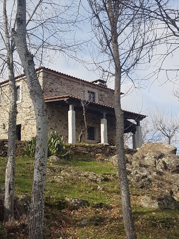 A stone building with a tiled roof, surrounded by trees and vegetation. - Casa da Janal for 4 people (Vimioso)