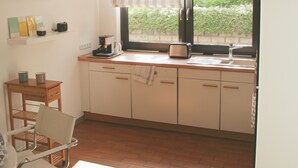 A kitchen with a window, a clock, and a coffee maker. - Living comfortably in Oberwalluf, enjoying the Rheingau, experiencing the Rhine - Main! (Walluf)