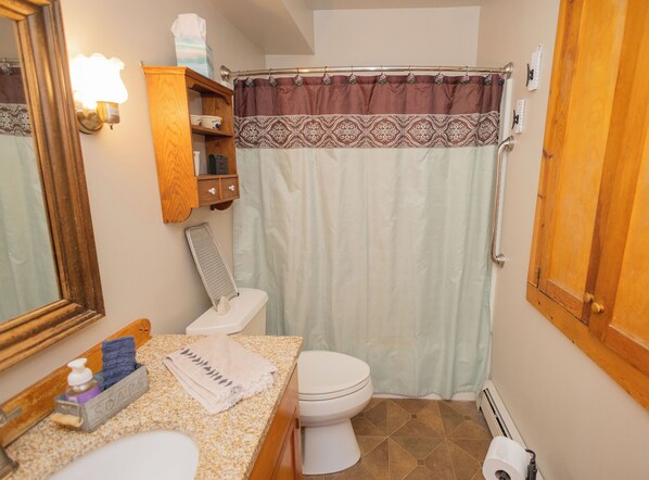 Une salle de bain avec des toilettes, un lavabo et un rideau de douche.