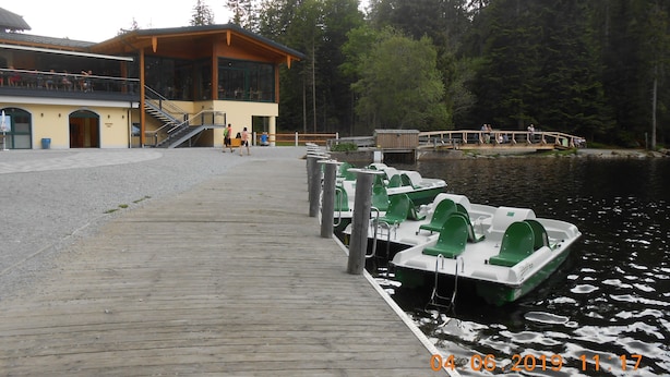 A wooden dock with several green and white boats moored at the end. There is a building with a yellow facade and a staircase leading to an upper level. - Nice holiday home "Aunt Emma" in Regen, Bavarian Forest, pets welcome (Kattersdorf)