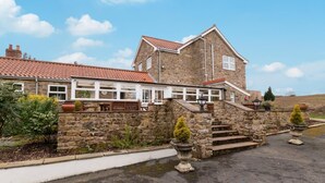 A stone building with a red-tiled roof, a covered patio area, and a stone staircase leading to the entrance. - Brock Cottage private Hot Tub DOG/Cat FRIENDLY* with on site fishing (Pickering)
