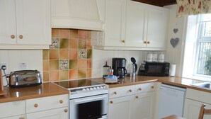 A kitchen with white cabinets, a stove, a microwave, and a dishwasher. - Brock Cottage private Hot Tub DOG/Cat FRIENDLY* with on site fishing (Pickering)