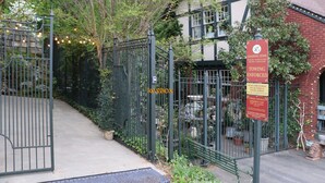 A gated area with a keybox, a loading zone sign, and a towing enforcement sign.
