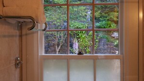 A bathroom with a frosted glass window, a towel rack, and a door with a handle.