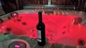 Un bain à remous avec une bouteille de vin et deux verres.