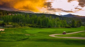 A golf course with a red golf cart, surrounded by lush green grass and trees, under a dramatic sky. - AUGUST SPECIAL! Luxury home-Heart of Telluride 3B+loft; deck/VIEWS/gas fireplace (Telluride)