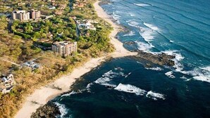 Vista aérea de una zona costera con edificios, una playa y el océano.