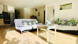 Un vaste espace de vie comprenant un canapé, une table basse et un téléviseur.