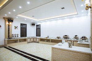 A spacious kitchen with a marble floor, wooden cabinets, and modern appliances. - Sun Halong Hotel (Ha Long)