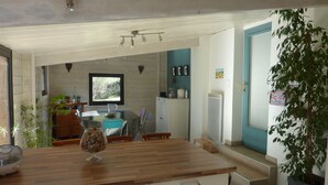 A modern kitchen with a wooden countertop, white cabinets, and a view of the dining area. - house between vineyards and garrigue (Vénéjan)