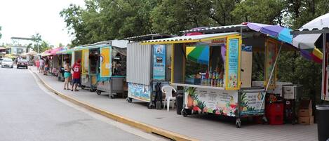 Una hilera de coloridos carros de comida en una acera.
