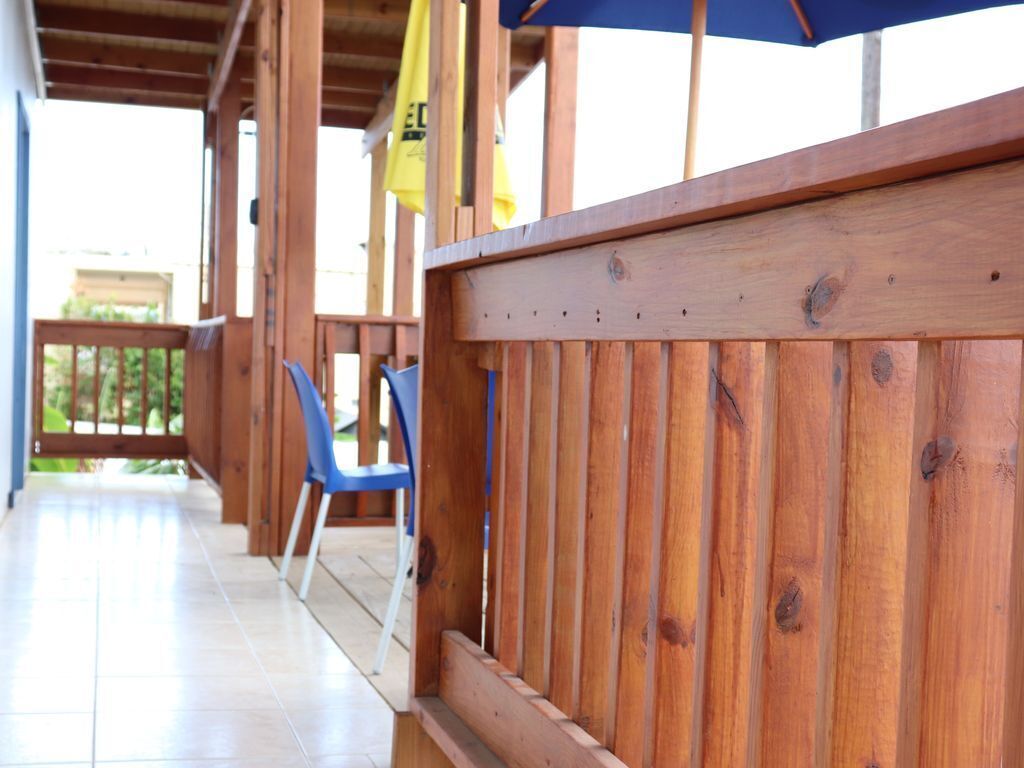 A wooden deck with a blue chair and a yellow flag.