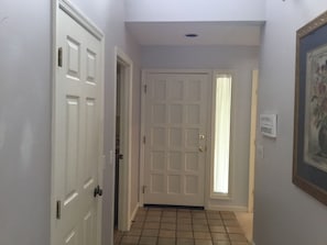 A hallway with white doors, a tiled floor, and a framed picture on the wall. - New Listing!! Lovely three bedroom home in Sea Pines Hilton Head. New addition.  (Hilton Head Island)