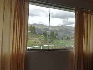 A room with a large window offering a view of a mountainous landscape. - Hacienda Cachimayo, Cusco (Cachimayo)