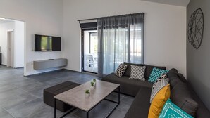 A modern living room with a sofa, coffee table, and TV. - Villa Bellavu in Rakalj (Rakalj)
