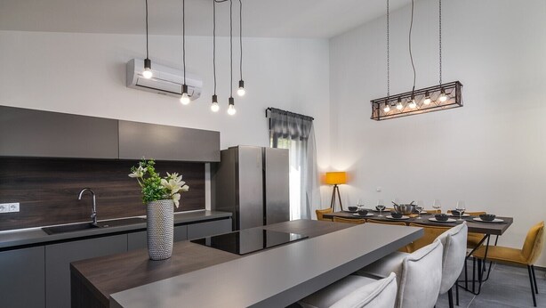 A modern kitchen with a central island, stainless steel appliances, and pendant lighting. - Villa Bellavu in Rakalj (Rakalj)