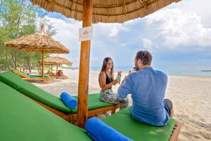 Una playa cerca, arena blanca, sillas reclinables de playa