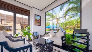 A modern living room with a sofa, chairs, a coffee table, and a bookshelf. - Fivitel Hoi An Hotel (Da Nang)