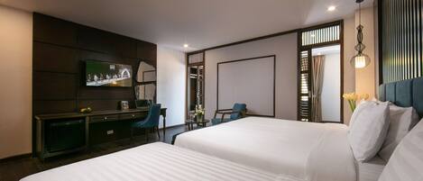 A hotel room with two beds, a TV, a desk, and a chair.
