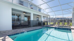 A swimming pool with a glass enclosure, a covered patio area, and outdoor seating. - 5🌟Clean Rated-Movie/Game Room, 3780 SF,❤️12p Dining (Davenport)