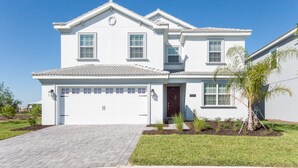 A two-story house with a white exterior, a garage, and a well-maintained lawn. - 5🌟Clean Rated-Movie/Game Room, 3780 SF,❤️12p Dining (Davenport)