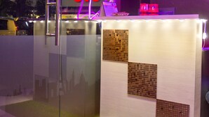 A modern interior with a glass partition, a neon sign indicating closure, and a wall-mounted display.