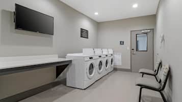 Une buanderie équipée d’un téléviseur à écran plat, d’un lave-linge et d’un sèche-linge.
