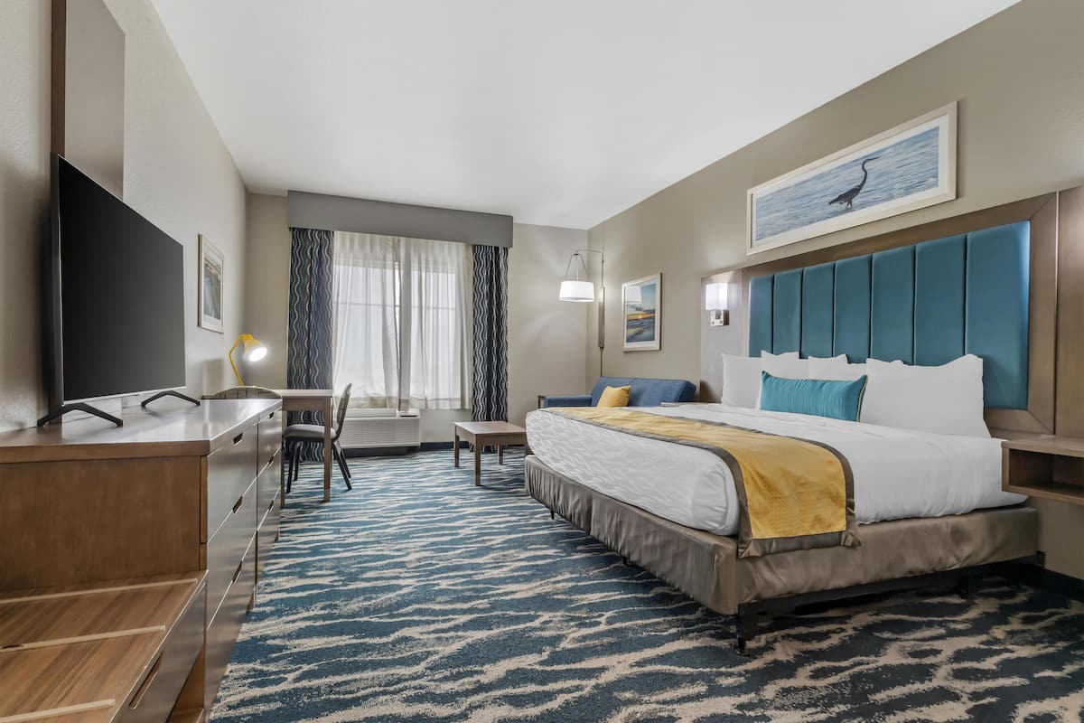 Una habitación de hotel con cama, escritorio y televisión.